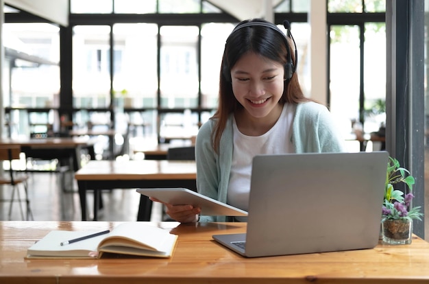 Aziatische vrouw student videoconferentie e-learning met leraar op computer in woonkamer thuis E-learning online onderwijs en sociale afstand op internet beschermen tegen COVID19-virussenxA