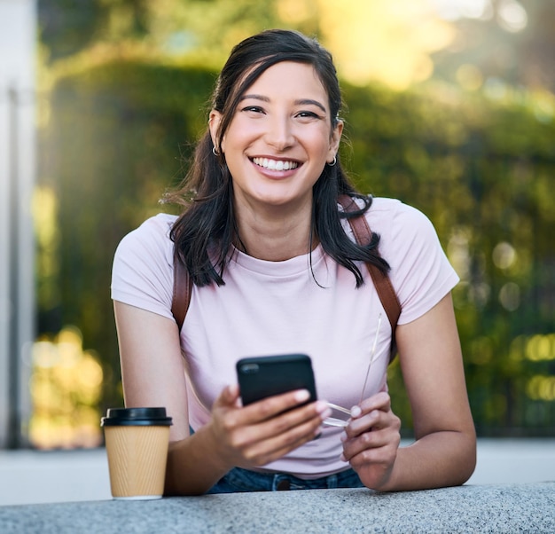 Aziatische vrouw telefoon en portret met koffie van een persoon in een Londense tuin blij met reizen Netwerken online communicatie en tekst van een reiziger op mobiele telefoon met onscherpe achtergrond op app