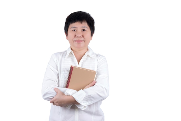 Aziatische vrouw van middelbare leeftijd in wit overhemd met boek in haar hand geïsoleerd op een witte background