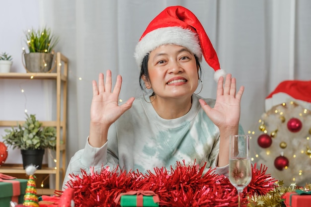 Aziatische vrouw viert nieuwjaar en kerstfeest met vrienden voor tabletvideogesprekken thuis