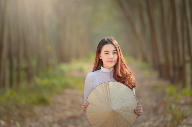 Aziatische vrouw Vietnam cultuur traditionele kleding in rubber bos tijdens zonsondergang, vintage stijl