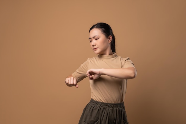 Aziatische vrouw was ziek van lichaamspijn die haar lichaam aanraakte en geïsoleerd stond op een beige achtergrond