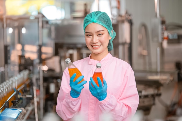 Aziatische vrouw werknemer aan het werk Voedselkwaliteitscontrole in fabriek en werknemer inspecteren productielijn drankentanker in zuivelfabriek Concept voedingsindustrie