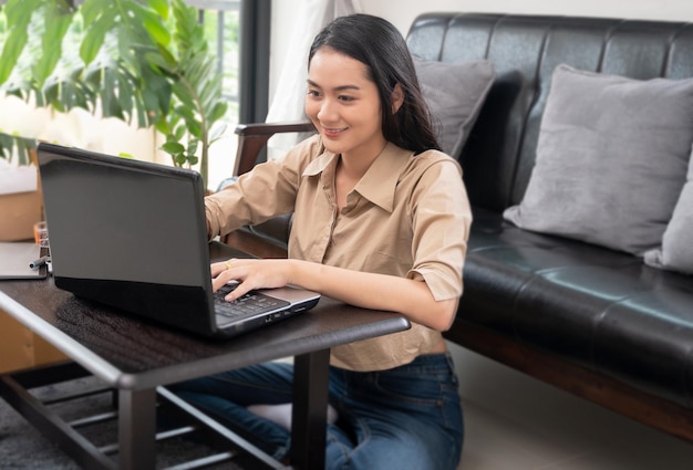 Foto aziatische vrouw werkt thuis met een computer