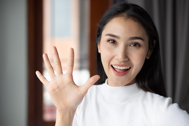 Aziatische vrouw wijzend tellen vijf vingers portret van gelukkig lachende aziatische vrouw die 5 vingers omhoog wijst voor nummer vijf of 5 punten concept door chinese aziatische volwassen vrouw model casual thema binnen