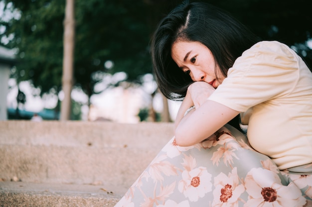 Aziatische vrouw zit alleen en depressief, stop met misbruik maken van huiselijk geweld, angst voor de gezondheid.