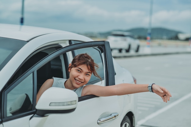 Aziatische vrouw zit personenauto op zomervakantie reizen. reizend concept. Ontspannen en genieten