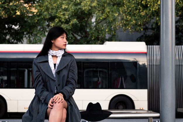 Aziatische vrouw zitten en wachten op de bus