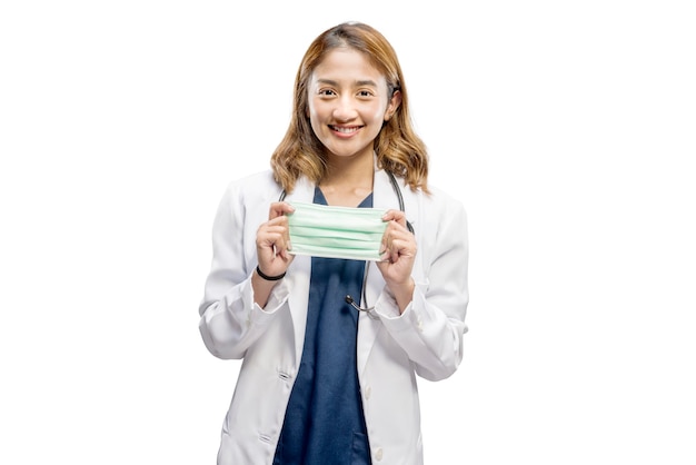 Aziatische vrouwelijke arts die met stethoscoop het gezichtsmasker houdt dat over witte achtergrond wordt geïsoleerd