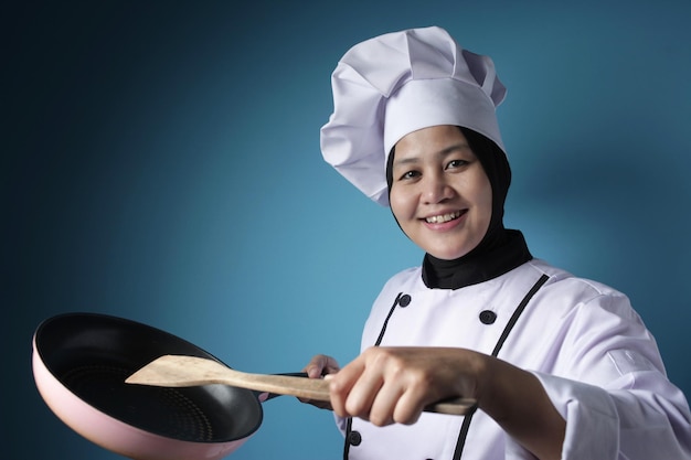 Aziatische vrouwelijke chef-kok klaar om te koken chef-kok met keukengereedschap spatula en pan