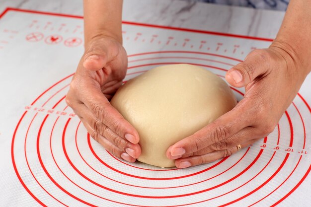 Aziatische Vrouwelijke Hand Afronding Rauw Brood Deeg, Bakproces Maken Van Japans Pluizig Wit Brood (Hokkaido Melk Brood)