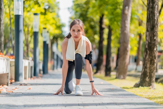 Aziatische vrouwelijke sportvrouw die veters bindt om te joggen op de weg in het park loopschoenen in het openbare park Actieve Aziatische vrouw die schoenveters bindt voordat ze loopt vrouw die schoenveters bindt