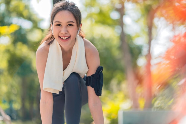 Aziatische vrouwelijke sportvrouw die veters bindt om te joggen op de weg in het park loopschoenen in het openbare park Actieve Aziatische vrouw die schoenveters bindt voordat ze loopt vrouw die schoenveters bindt