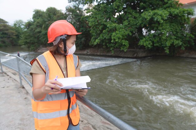 Aziatische vrouwelijke techniek werkt xA bij rioolwaterzuiveringsinstallatie Mariene bioloog die watertestresultaten analyseert Wereldmilieudagconcept