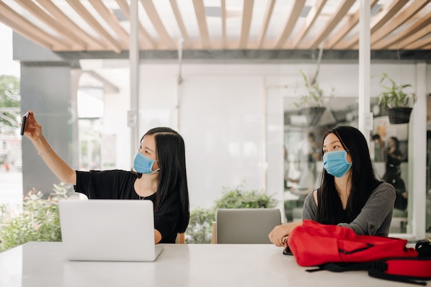 Aziatische vrouwen die gezichtsmaskers dragen in het kantoor