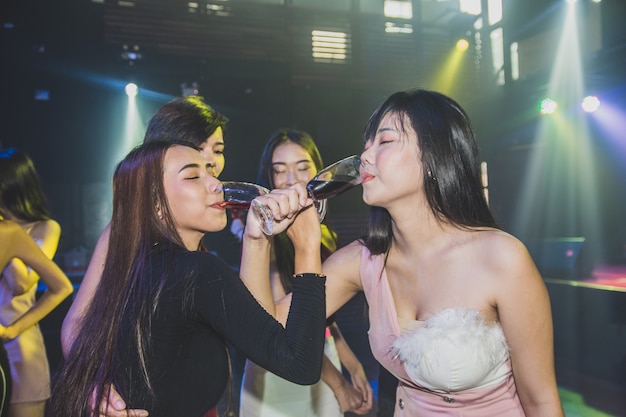 Aziatische vrouwen die in de club drinken