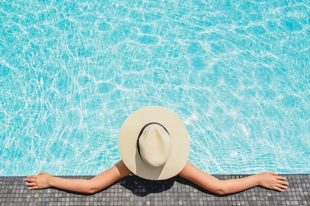 Aziatische vrouwen die in de vakantie van de zwembadzomer ontspannen op strand