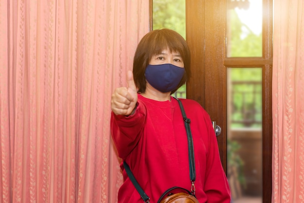 Aziatische vrouwen dragen een chirurgisch masker of gezichtsmasker voordat ze het huis verlaten om de infectie van covid-19 te verminderen