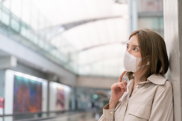 Aziatische vrouwen dragen maskers tijdens het reizen op de luchthaventerminal. Nieuw normaal, covid19-ziektepreventieconcept.