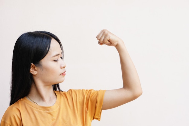 Aziatische vrouwen duwen hun spieren om te pronken met hun kracht