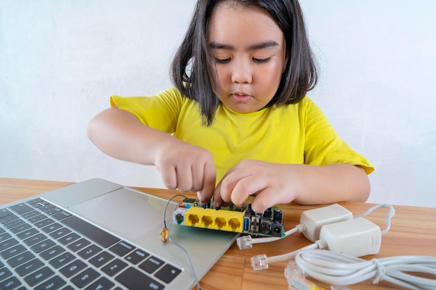 Aziatische vrouwen leren eenvoudige elektrische circuits door online te studeren vanaf uw laptop om informatie te vinden over het aansluiten van circuits