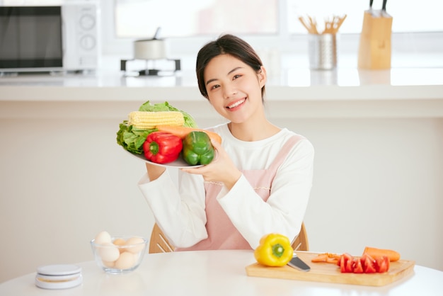 Aziatische vrouwen ontspannen aan de keukentafel met verse fruitgroenten