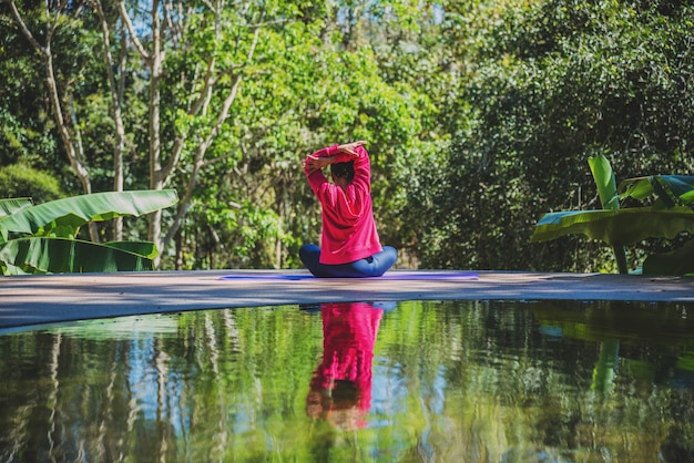 Aziatische vrouwen ontspannen in de vakantie. Speel als yoga bij het zwembad. Jonge vrouw reist natuur ze staande oefening.