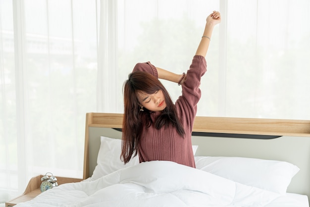 Aziatische vrouwen op bed en wakker in de ochtend