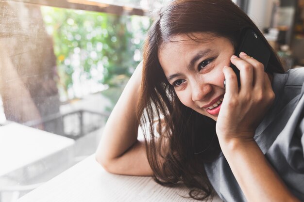 Aziatische vrouwen praten graag met mobiele telefoons in coffeeshops