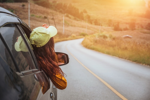 Aziatische vrouwen reizen in een auto die uit het raam kijkt.