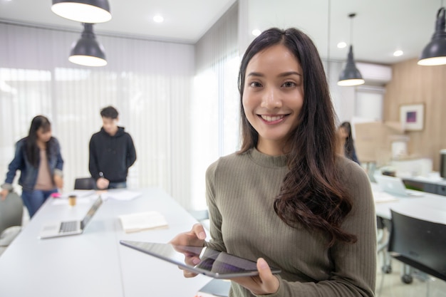 Aziatische vrouwen studenten lachen en hebben plezier en gebruiken slimme telefoon en tablet