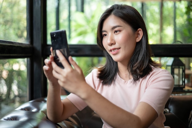 Aziatische vrouwen werken en luisteren naar muziek op mobiele telefoons.