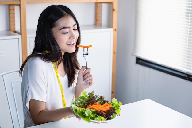 Foto aziatische vrouwen zijn eet een salade van groenten voor een goede gezondheid