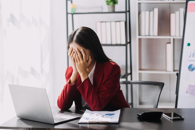 Aziatische vrouwen zijn gestrest tijdens het werken op een laptop Vermoeide aziatische zakenvrouw met hoofdpijn op kantoor voelt zich ziek op het werk kopieer ruimte
