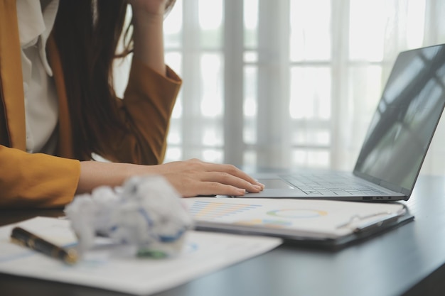 Aziatische vrouwen zijn gestrest tijdens het werken op een laptop Vermoeide aziatische zakenvrouw met hoofdpijn op kantoor voelt zich ziek op het werk kopieer ruimte