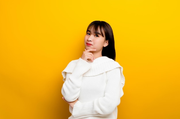 Aziatische vrouwen zijn schattig, jong, schattig, gelukkig, optimistisch, ontspannen, goede lichamelijke gezondheid. De foto is genomen in een studio met gele achtergrond