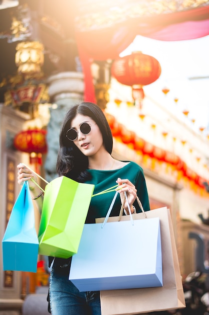 Foto aziatische vrouwen zijn verslaafd aan winkelen of shopaholic winkelen in de stad van china