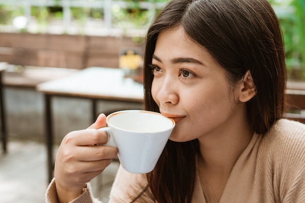 Aziatische vrouwendrank in koffiewinkel