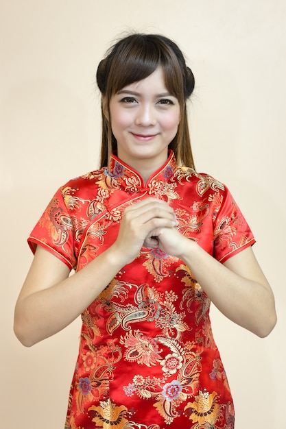 Aziatische vrouwengroet in traditionele Chinees of cheongsam