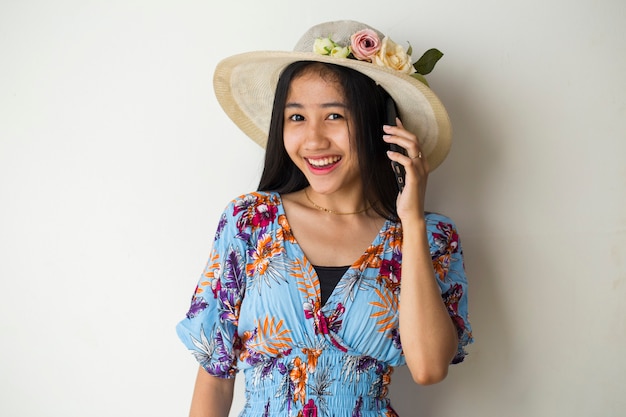 Aziatische vrouwenreiziger die op de mobiele telefoon spreekt. zomer reizen concept op witte achtergrond