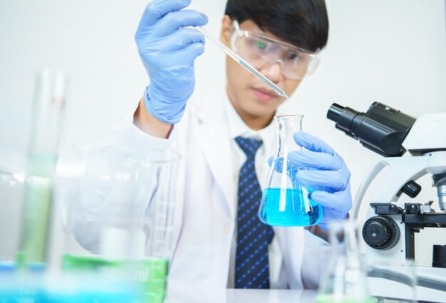 Aziatische wetenschappers bestuderen serieus de chemische samenstelling in het laboratorium Gespecialiseerd in jonge biotechnologie Gebruik geavanceerde microscoopapparatuur