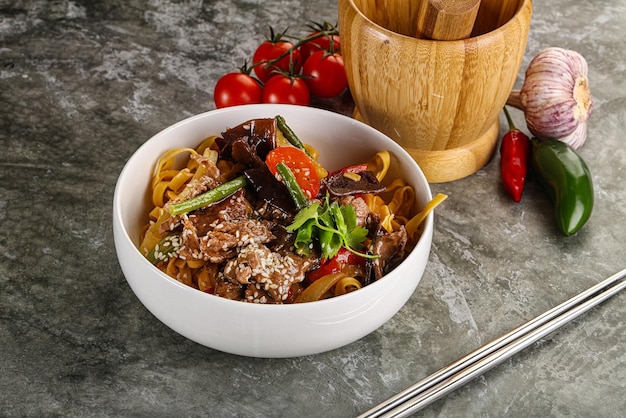 Foto aziatische wok met noedels, groenten en rundvlees