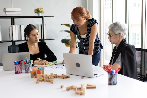 Aziatische zakelijke woaman team dat werkt op laptopcomputer in vergaderruimte. Professionele zakenmensen brainstormen en teamwork concept.