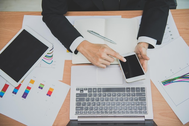 Aziatische zakenman die aan het bureau werkt met laptoptablet en smartphone van bovenaanzicht Moderne Thaise man werkt op kantoor Hoge hoek van werknemer die zit voor werk in een bedrijf