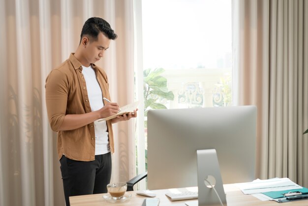 Aziatische zakenman die aan laptop werkt en over het werk denkt