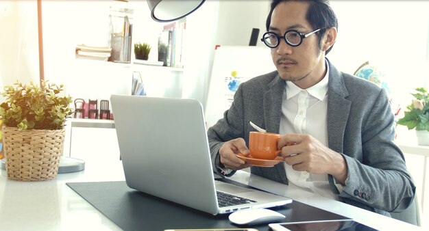 Aziatische zakenman dragen lenzenvloeistof in office.