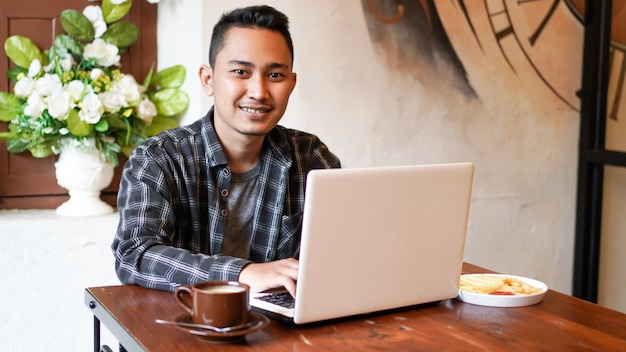 Aziatische zakenman typen op laptop in café