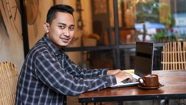 Aziatische zakenman typen op laptop in café