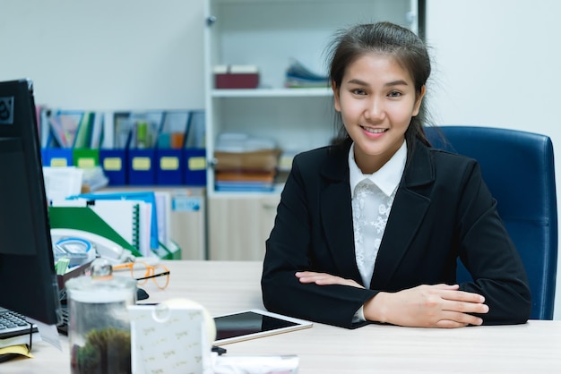 Aziatische zakenvrouw die aan het bureau op kantoor werktThailand werknemer vrouw glimlach Mooie secretaresse heeft een mooie glimlachLady klerk overuren bij het bedrijf