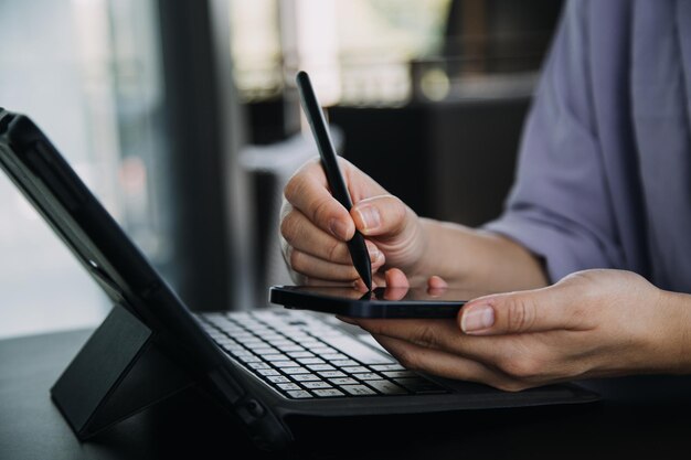 Aziatische zakenvrouw die rekenmachine en laptop gebruikt voor het doen van wiskundefinanciering op een bureau, belastingrapport, boekhoudstatistieken en analytisch onderzoeksconcept